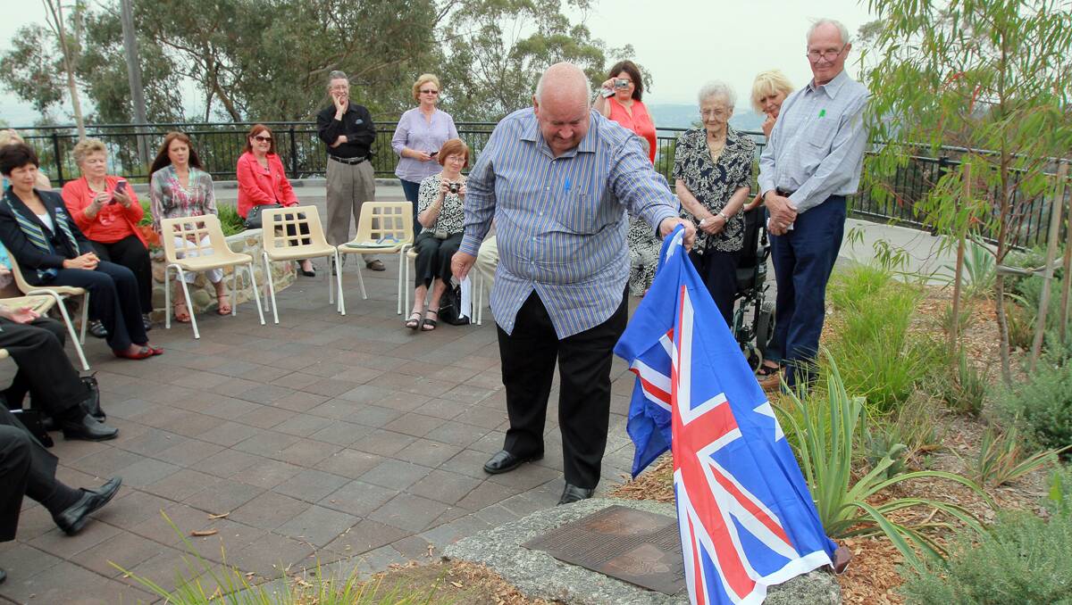 UNVEILED: Dawson family friend Lance Smith unveils the plaque marking the final resting place of Smoky and Dot Dawson’s ashes at Oxley Lookout, Tamworth. Photo: Robert Chappel 031112RCB028