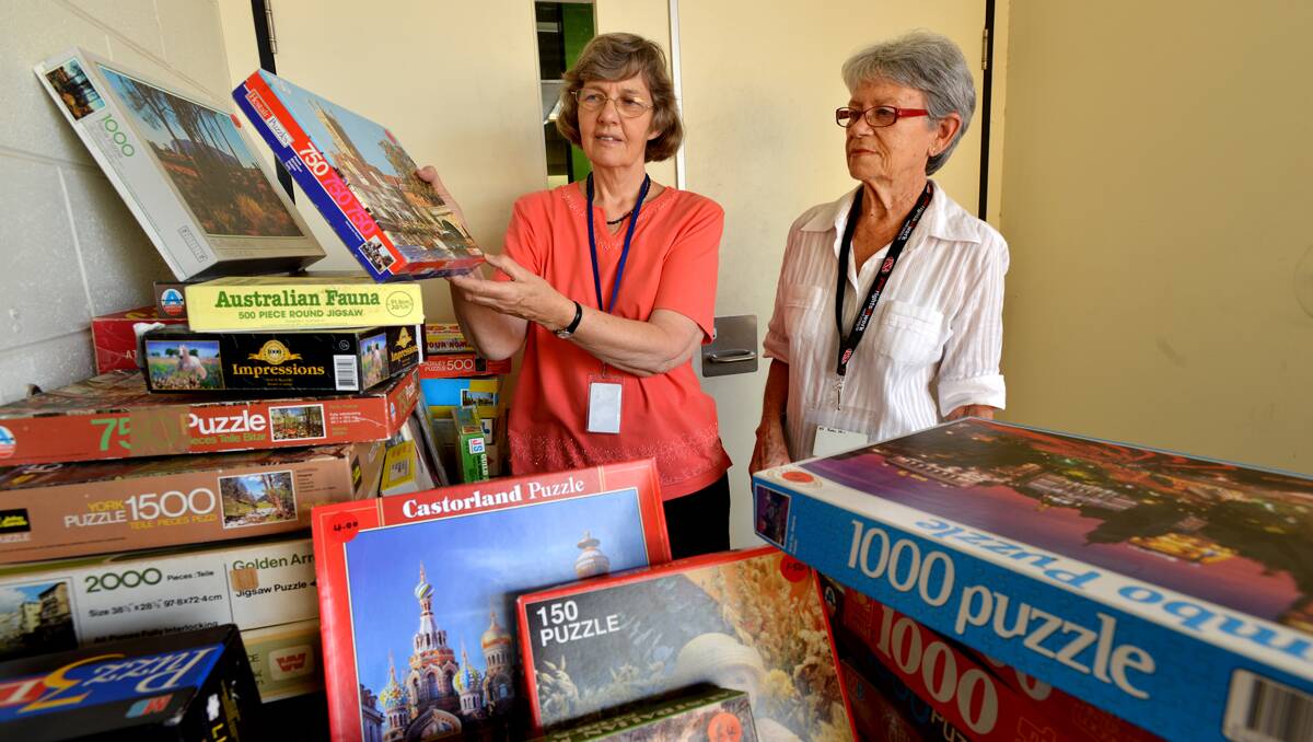 ALL THE PIECES FIT: Jan Morris, left, and Judy Sheargold from the Friends of Tamworth Libraries group with some of the jigsaws up for sale on Saturday. Photo: Barry Smith 190213BSE03