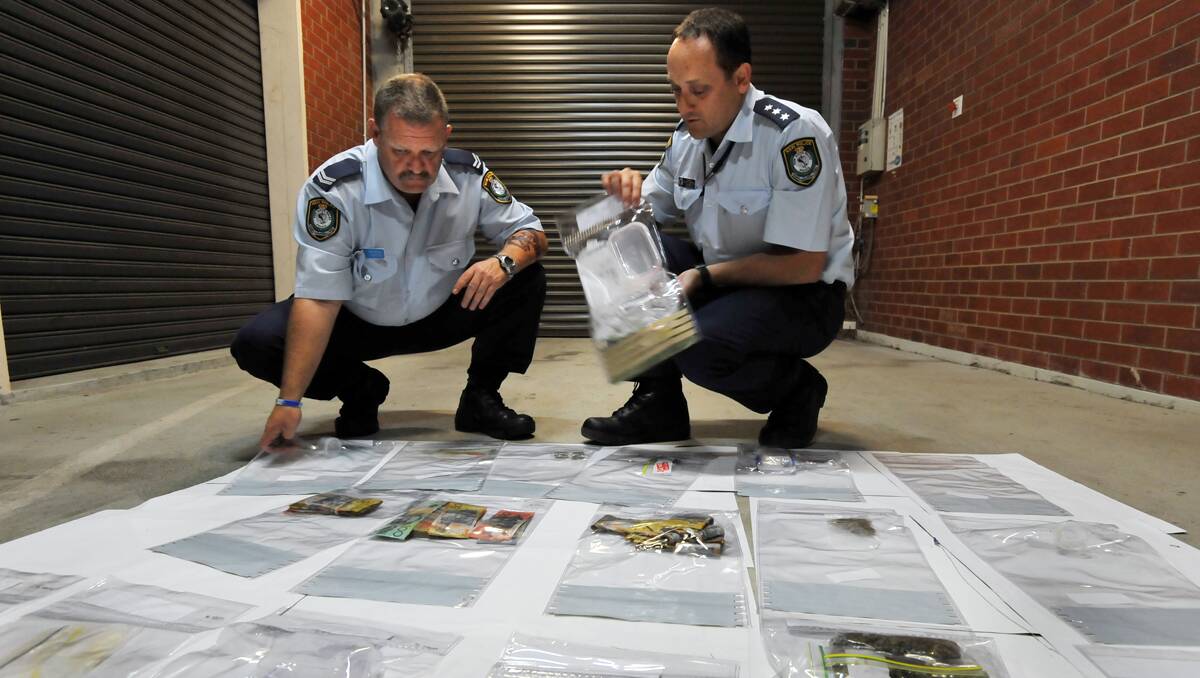 Senior Constable Stuart Churchill and Acting Inspector Stuart Campbell with some of the drugs and cash from yesterday's raid at two Westdale properties. Photo: Barry Smith