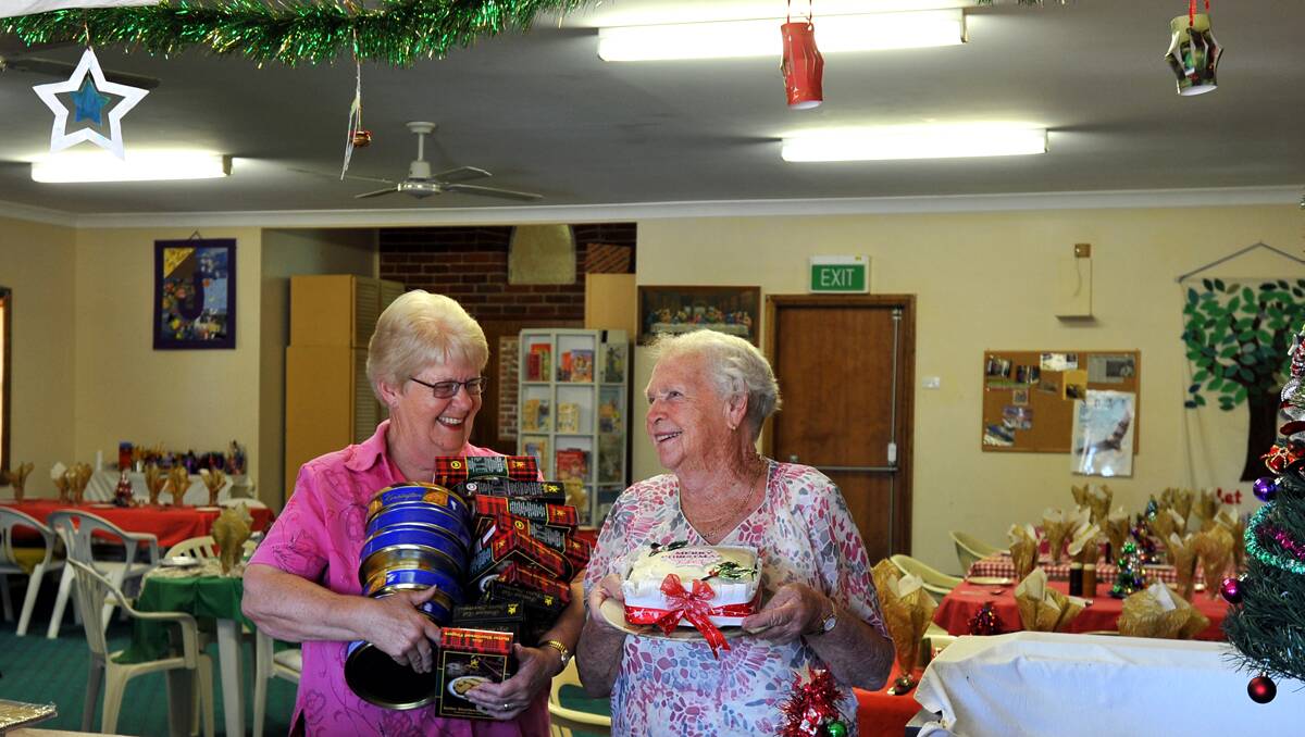 SPREADING CHEER: From left, Larraine Abra and Jean Jansen prepare for Attunga’s annual Anglican Church Christmas tea.  Photo: Barry Smith 041212BSF05
