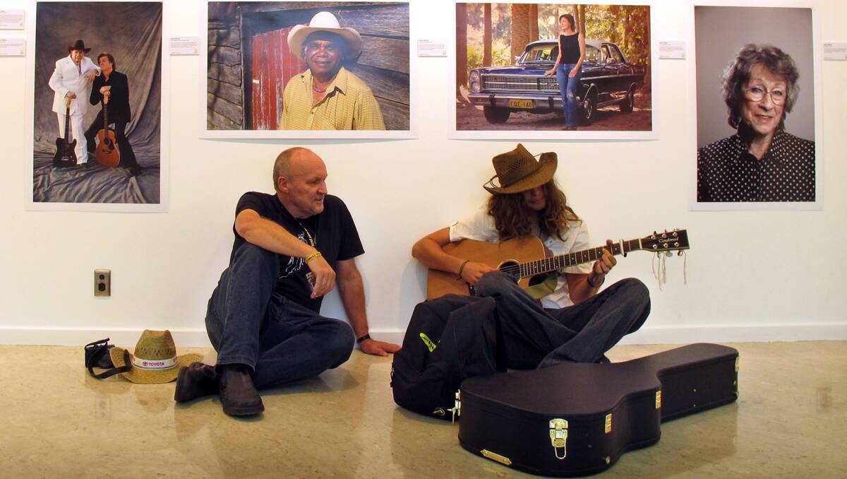Photographer John Elliott chats with a busker at the launch of his Gifted Country exhibition in Tamworth. Photo: Kitty Hill