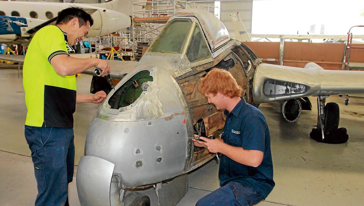 STUDENT INVESTMENT: Nelson King and Luke Murray working on the  restoration of the Vampire jet that used to be in Tamworth’s Hands of Fame Park as part of their aviation studies.   Photos: Robert Chappel 081112RCD003