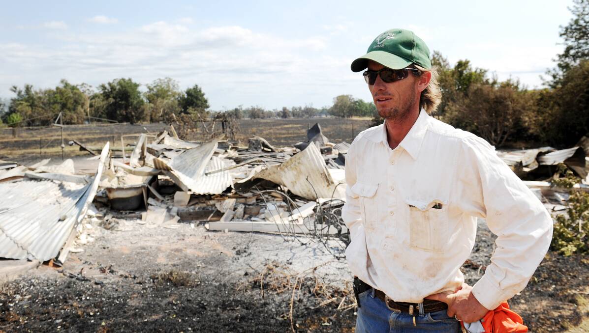 DEVASTATION: Steve Munge returns to his parents’ Bulgaldie property that was destroyed by the fire  that threatens Coonabarabran.  A watch and act is in place for the 40,000 hectare bushfire that is burning uncontrolled in the Warrumbungle National Park. 