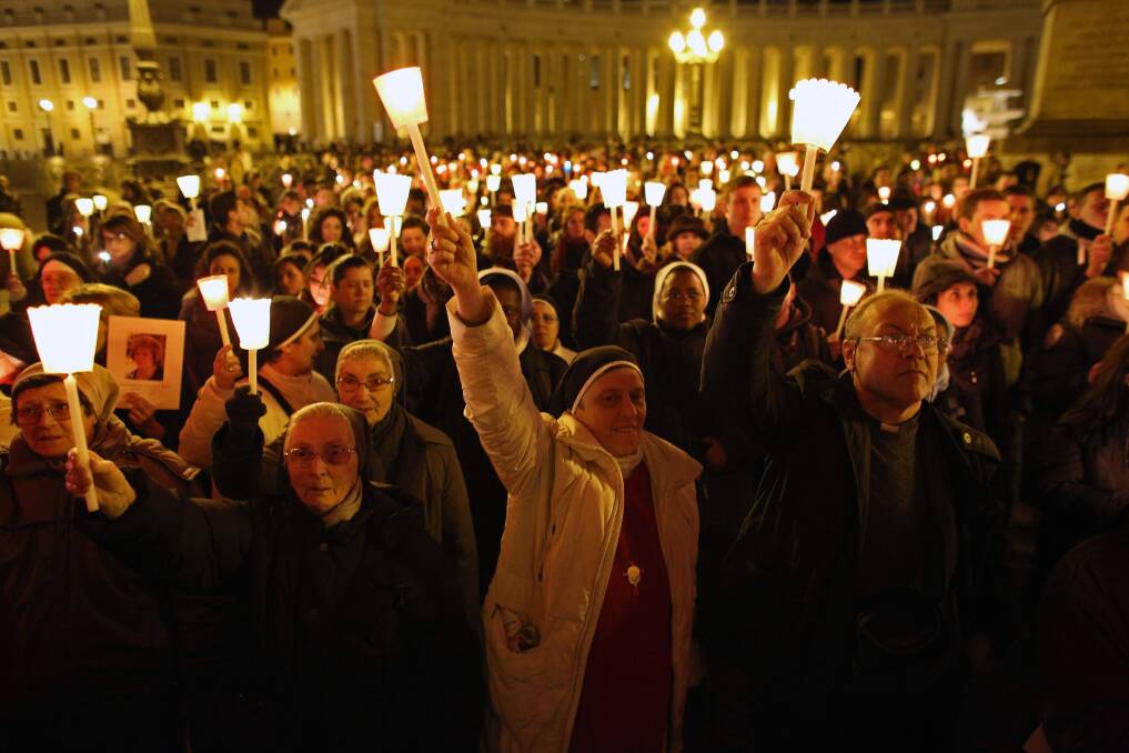 Pilgrims and clergy members hold a candle-lit vigil in Saint Peter's Square, facing Pope Benedict XVI's private apartment, after his final weekly public audience in Vatican City, Vatican. Photo by Oli Scarff/Getty Images