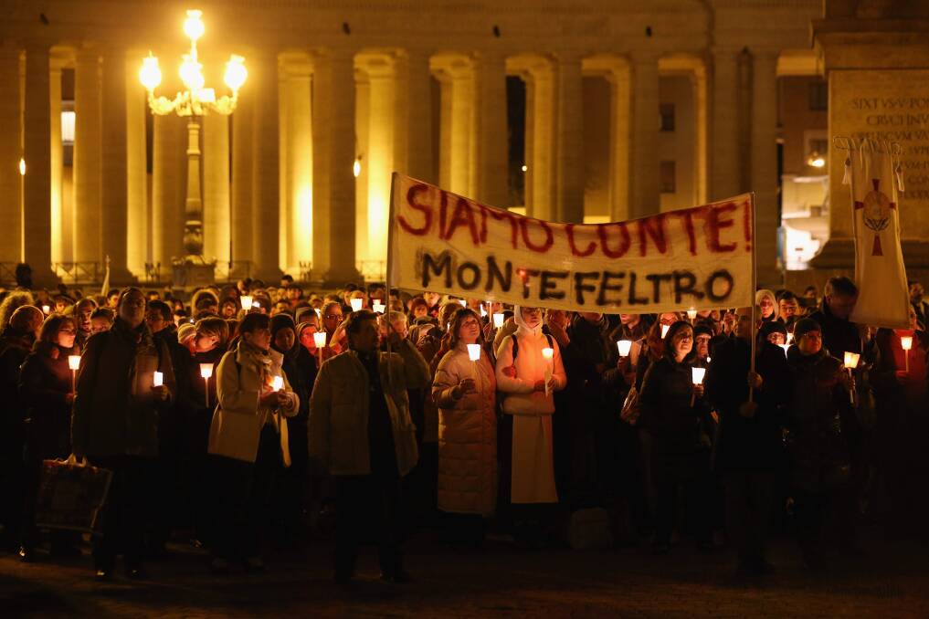 Pilgrims and clergy members hold a candle-lit vigil in Saint Peter's Square, facing Pope Benedict XVI's private apartment, after his final weekly public audience in Vatican City, Vatican. Photo by Oli Scarff/Getty Images