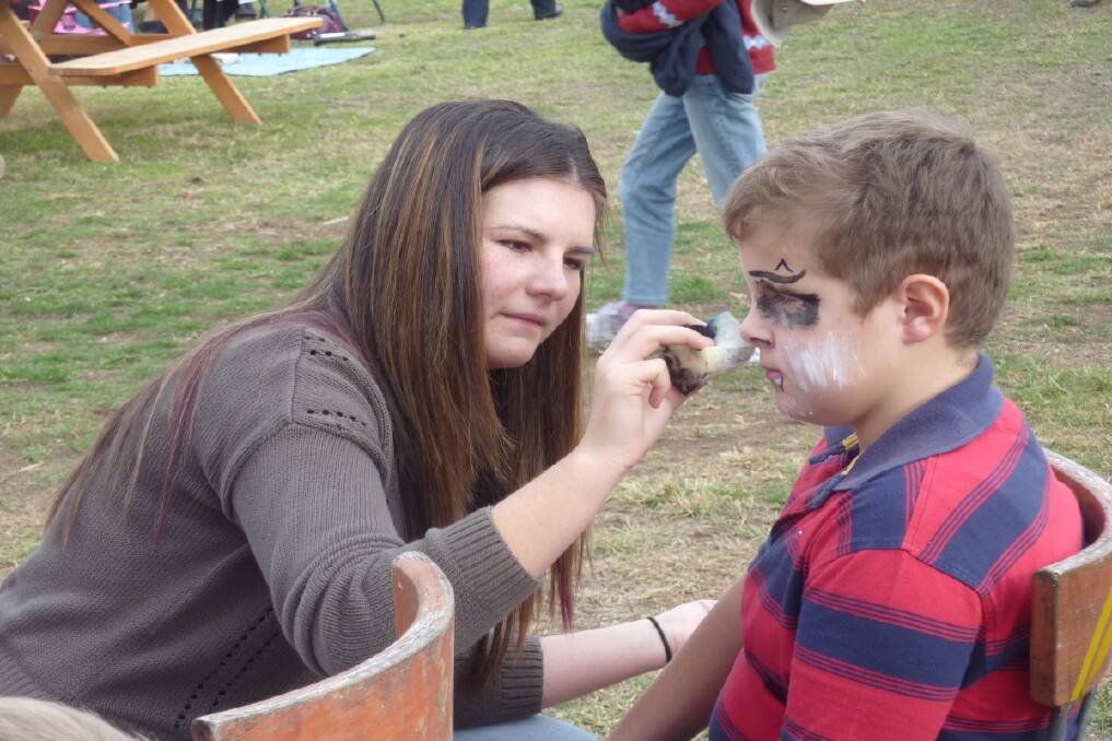 CONCENTRATION: Kaylee Townsend paints the face of Marcus Ryan. 